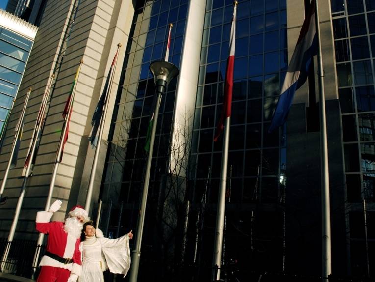 Der Weihnachtsmann zusammen mit einem Engel vor den Europaparlament in Brüssel
