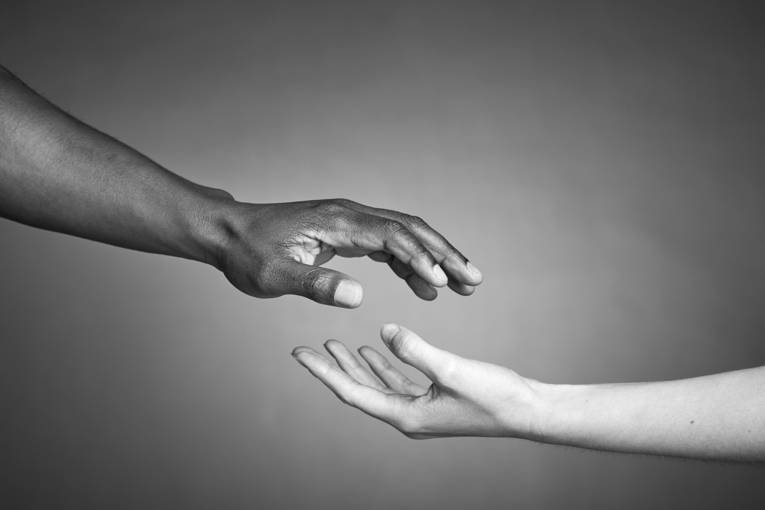 Black and white hands together against racism