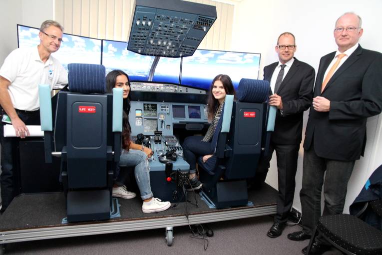 Präsentieren das Projekt im Airbus A320-Flugsimulator: Martin Dutschek (v. l.) vom Unternehmen Sim&Learn, die beiden Schülerinnen Rinna Kuraischi (16) und Regina Ruff (15) mit Ulf-Birger Franz, Wirtschaftsdezernent der Region Hannover, und Hans-Ulrich Koch, Teamleiter in der Berufsberatung der Agentur für Arbeit.