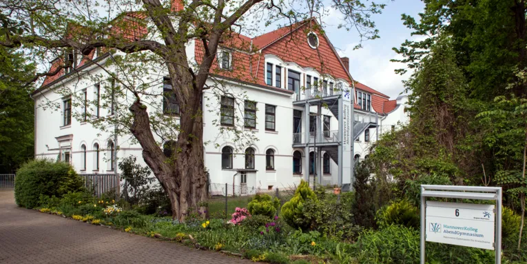 Gebäude mit weißer Fassade und rotem Ziegeldach.