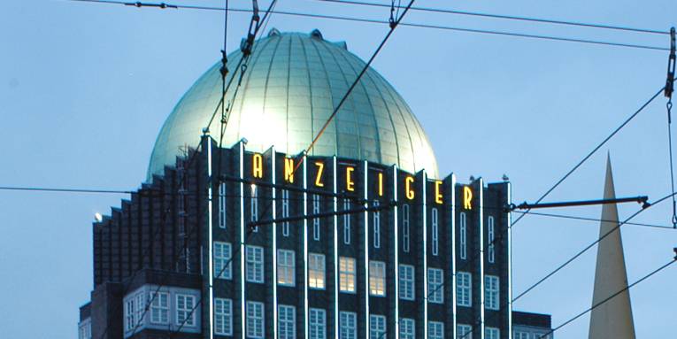 Backsteingebäude über zehn Geschosse mit charakteritischer Dachkuppel.