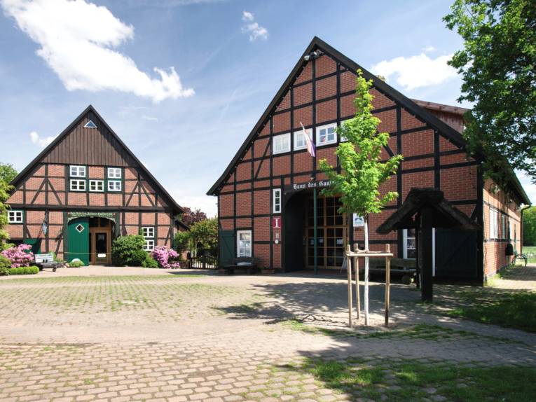 Zwei Fachwerkgebäude stehen auf einem Hofgelände.