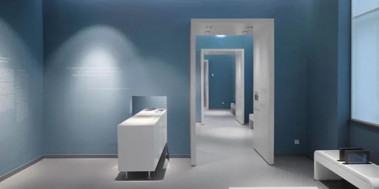 Ein Ausstellungsraum mit einem Medientisch und einer Sitzbank mit zwei integrierten Tablet-PCs.