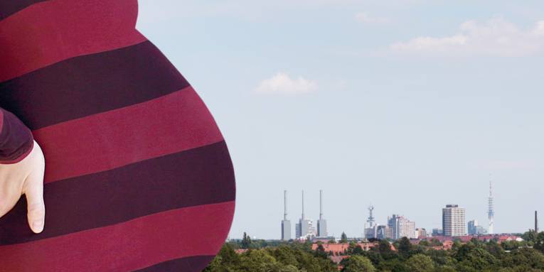 Eine Frau stemmt ihre Hände in den unteren Rücken und streckt ihren Babybauch nach vorne. Hinter ihr ist das Stadtbild von Hannover mit prägenden Gebäuden wie dem Heizkraftwerk Linden ("die drei warmen Brüder") und dem Fernsehturm zu sehen.