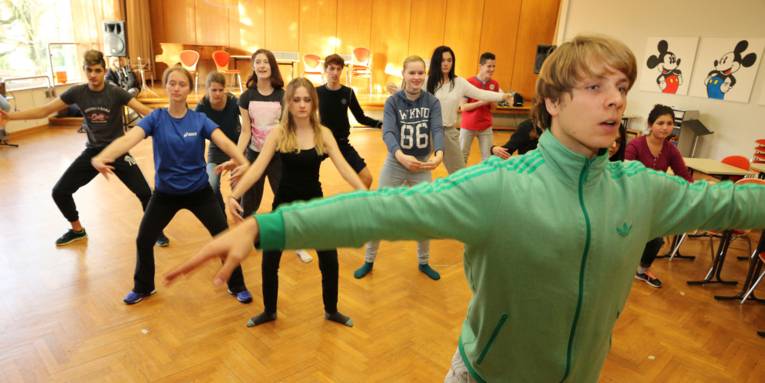 Elf Schüler und ein Trainer bei einer Tanzprobe.