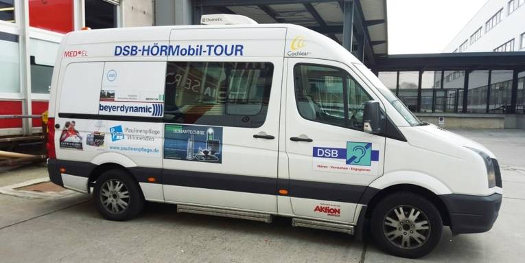 Eine Art Lieferwagen mit der Aufschrift "DSB-HÖRMobil-Tour"