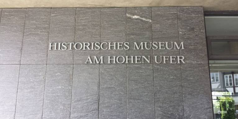 Dieses Bild zeigt den Namen des Museums am Eingang. Es steht geschrieben "Historisches Museum Am Hohen Ufer".