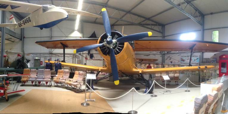 Das Bild zeigt in Panoramasicht eine Halle des Luftfahrtmuseums mit verschiedenen Flugzeugen und Flugzeugteilen.