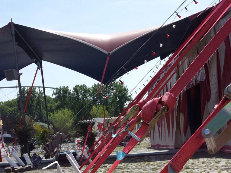 Ein weiß-rotes Zirkuszelt mit überdachtem Eingangsbereich.