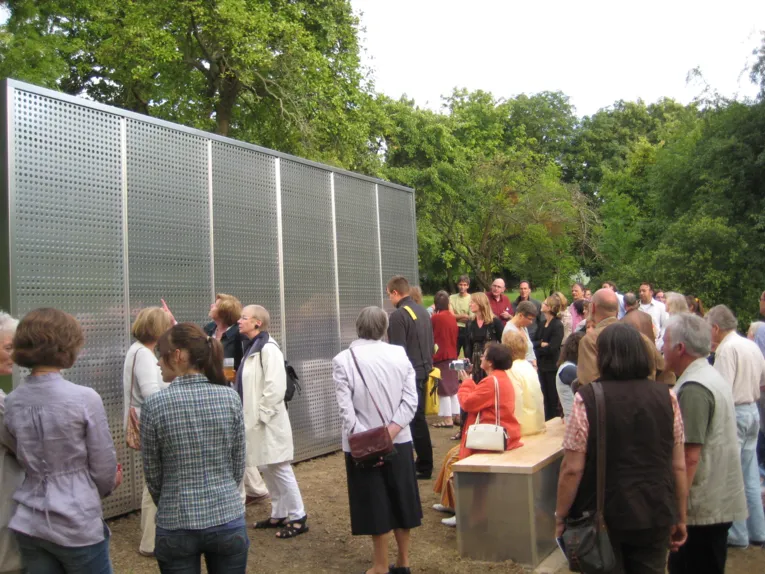 Menschen vor einer großen Wand aus Metall