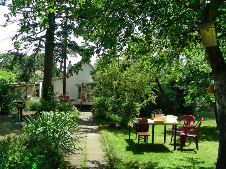 Garten mit Stühlen und einem Tisch auf dem Rasen.