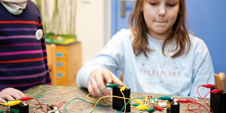 Kinder, die einen Schaltkreis aufgebaut haben