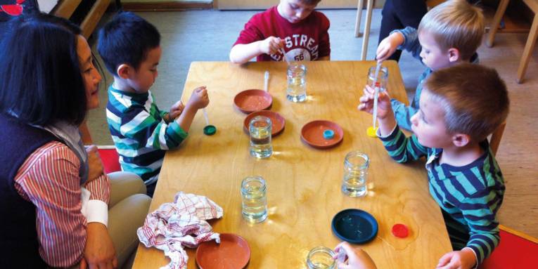 Kinder experimentieren mit Pipetten und Wasser
