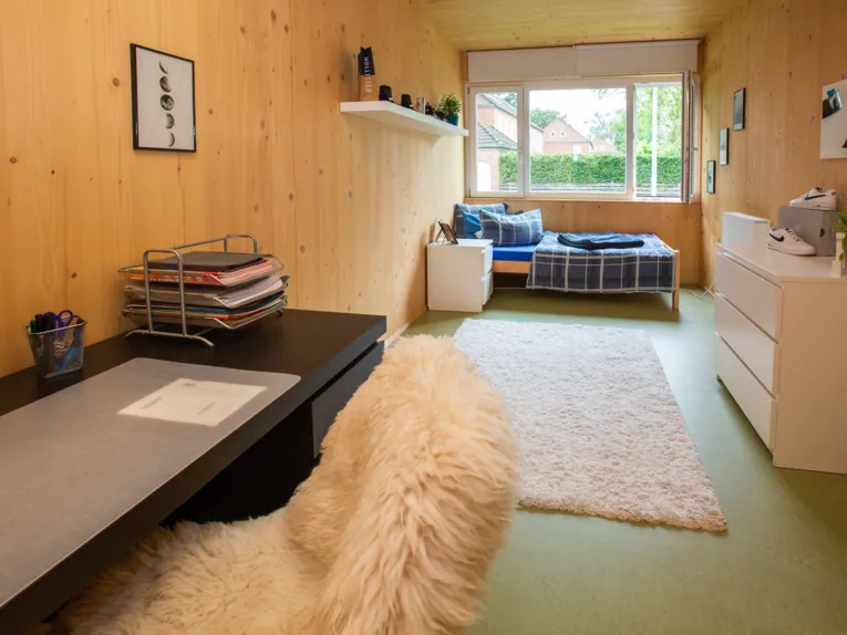 Jugendzimmer mit Bett, Schreibtisch und Stauraum.