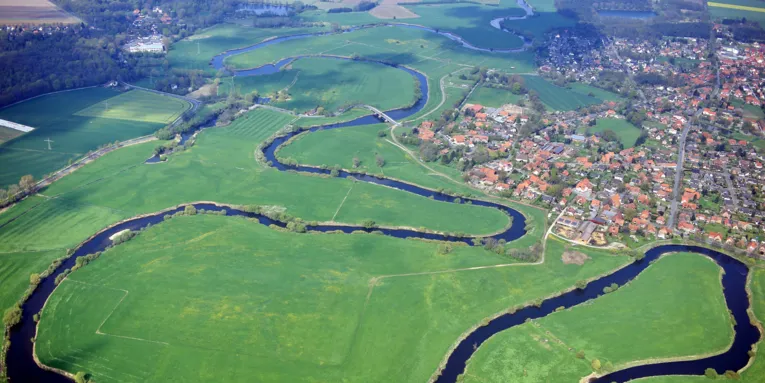 Die Leine schlängelt sich sehr kurvig durch eine Wiesenlandschaft.