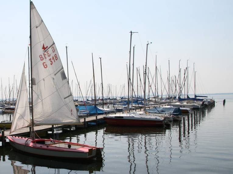 Steg mit Segelbooten, das erste Boot hat gesetzte Segel