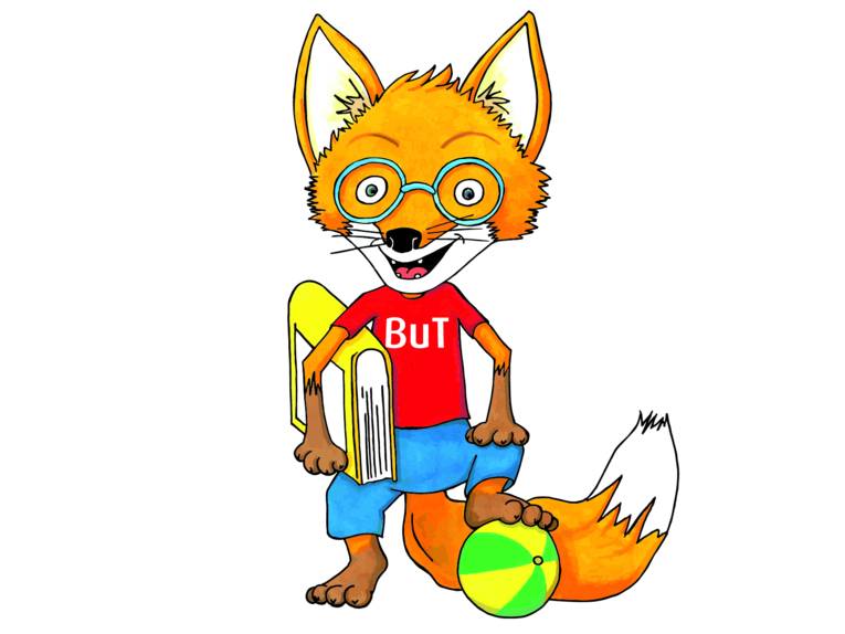 Ein gezeichneter Fuchs trägt ein rotes T-Shirt, darauf steht "BuT". Mit der rechten Vorderpfote hält er ein Buch, die linke Hinterpfote ruht auf einem Ball. So steht er aufrecht und blickt durch eine Brille zum Betrachtenden.