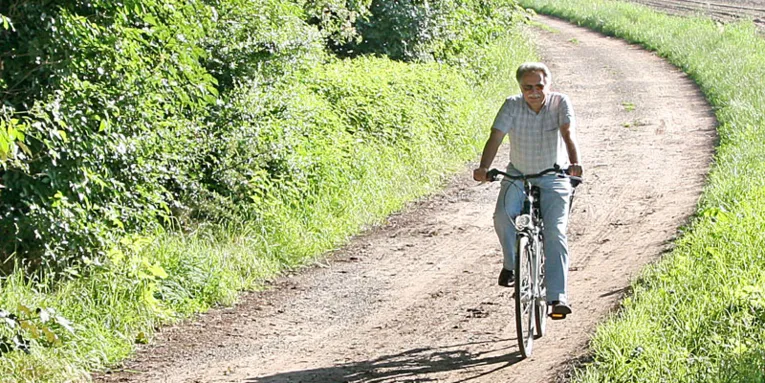 Radfahrer auf einem unbefestigten Weg im Sommer bei Sonnenschein