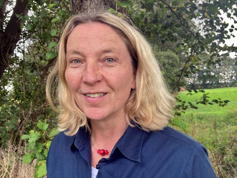 Portr&auml;tfoto einer Frau in einem blauen Poloshirt mit Naturparklogo.