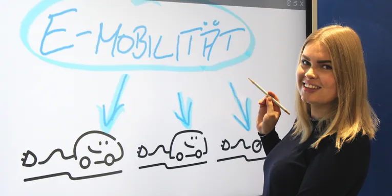 Eine Dame vor einem elektronischen Flipchart erklärt etwas zum Thema Elektromobilität