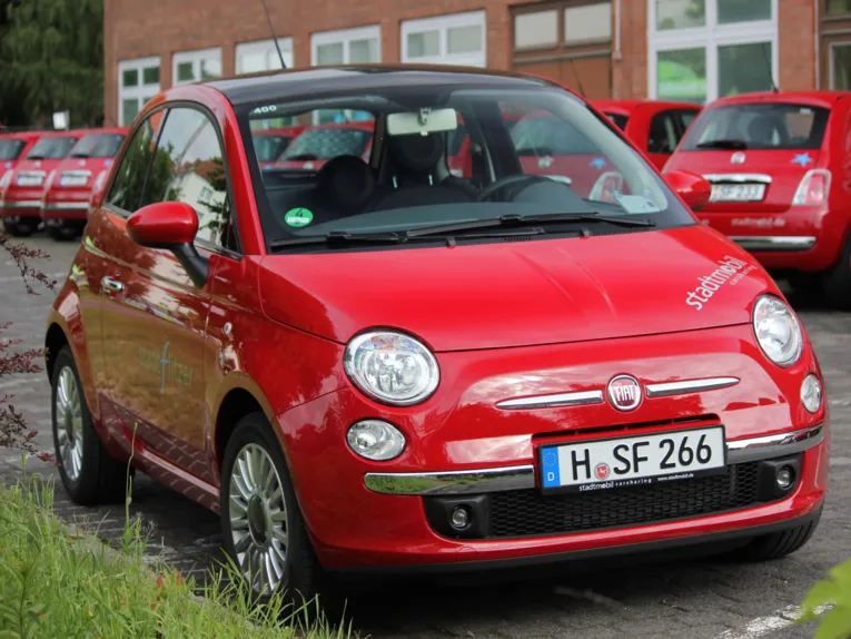 Roter Kleinwagen auf Abstellplatz.