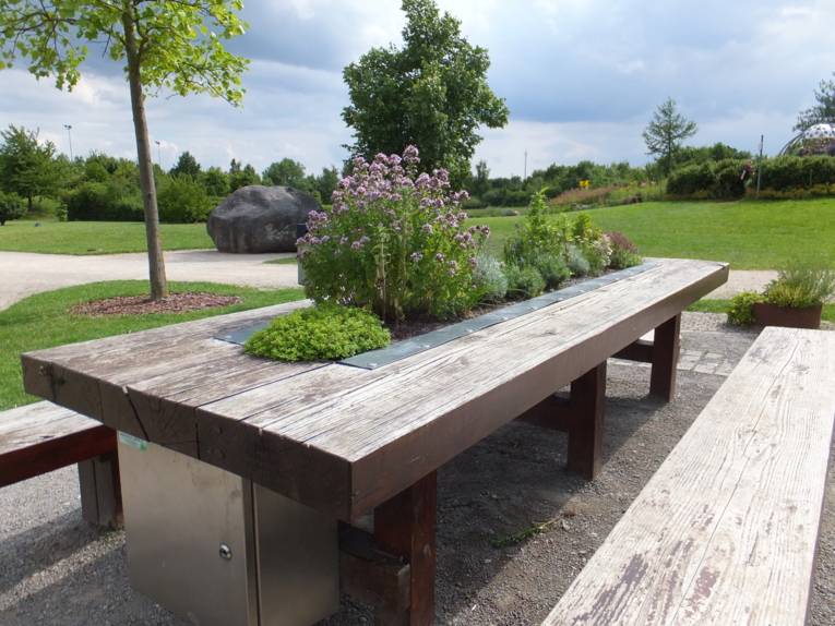 Holztisch mit eingelassenem und bepflanztem Blumenkasten