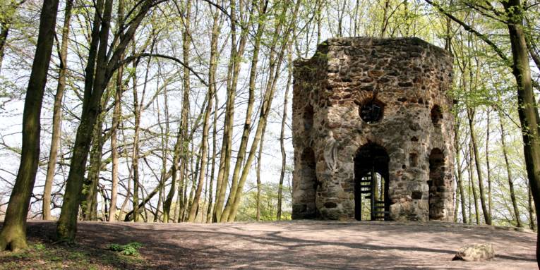 Alter Turm in einem Landschaftsgarten.