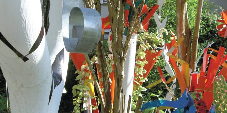 Bunte Kunstwerke in einem Garten.
