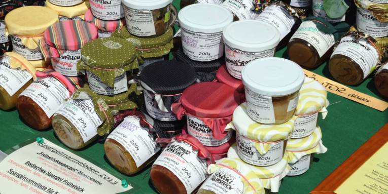 Verschiedene Marmeladengläser stehen auf einem Verkaufstresen.