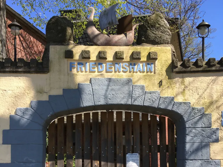 Mauer mit Tor und der Inschrift Friedenshain