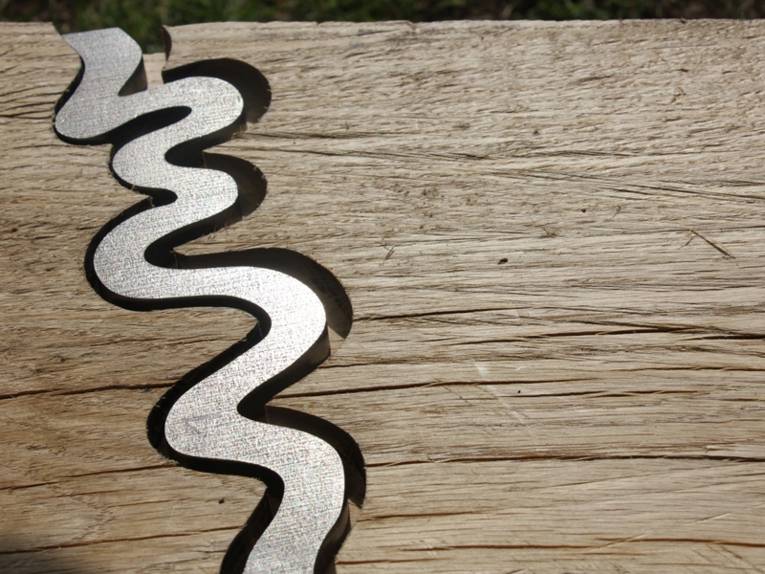 Holzplanke mit eingefrästem Fluss aus Metall