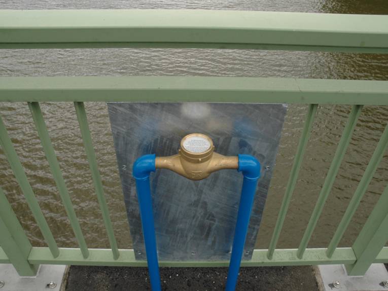 Wasserzähler, mit Hilfe von Stahlrohr montiert, mit Informationen zum Bauwerk oder Gewässer