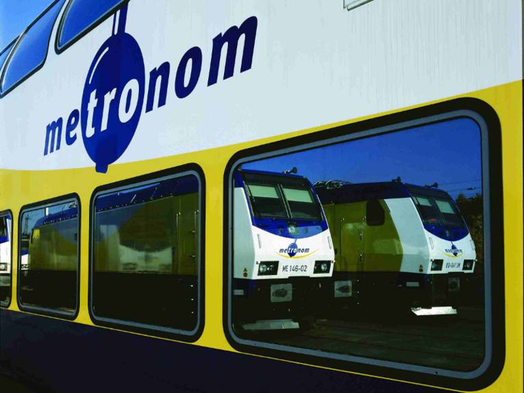 Zug in deren Fenstern sich zwei Triebwagen spiegeln. 