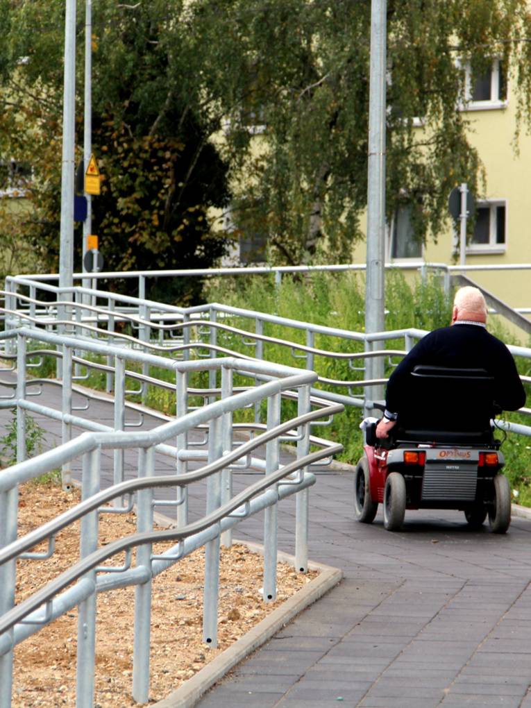 Ein Mann fährt mit einem kleinen Elektrofahrzeug die Rampe zum S-Bahnsteig Empelde hinauf.