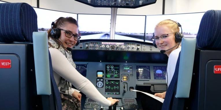 Zwei Frauen in einem Flugsimulator.