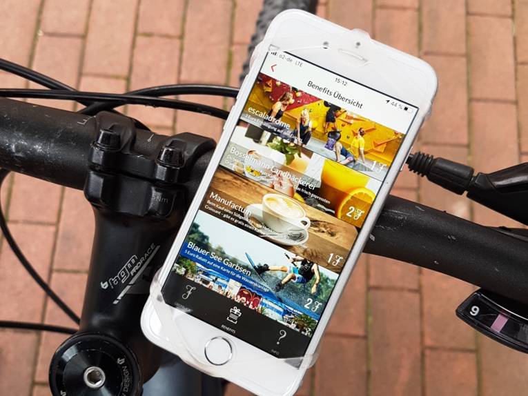 Smartphone mit laufender App an einem Fahrradlenker.