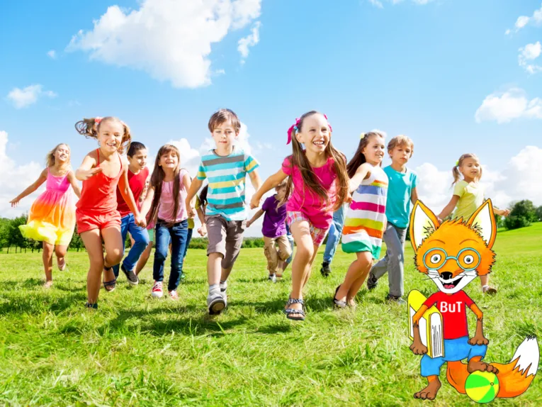 Laufende Kinder auf einer grünen Wiese. Die Kinder halten sich anden Händen.