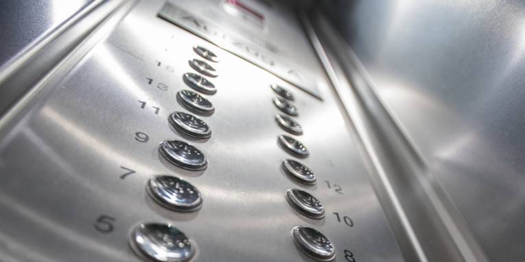 Zahlen stehen neben runden Knöpfen. Darüber lassen sich die Stockwerke wählen, die der Aufzug anfahren soll.