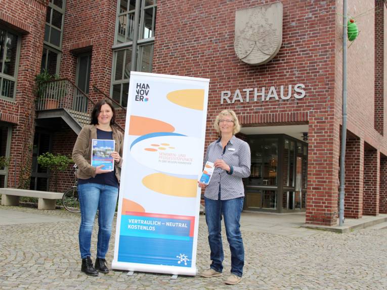 Zwei Frauen stehen vor dem Rathaus in Gehrden und präsentieren Informationsmaterial.
