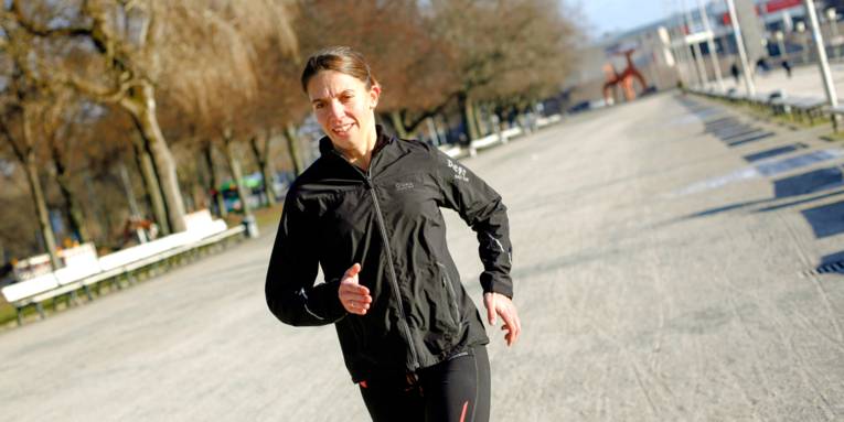 Eine Frau läuft am Nordufer des Maschsees in Hannover, sie trägt Sportkleidung.