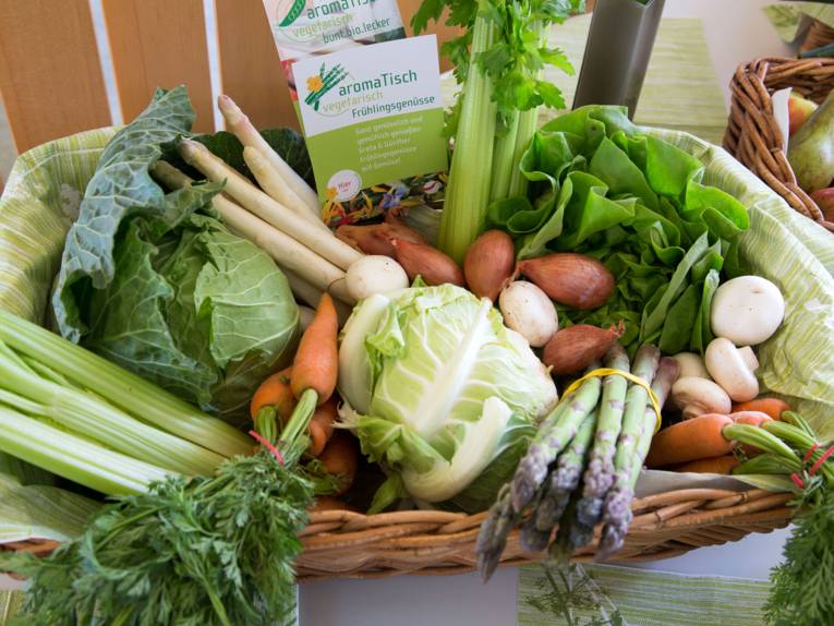 Ein Krob voll mit Gemüse wie Karotten, Blumenkohl, grüner und weißer Spargel, Zwiebeln, Sellerie und Kopfsalat.