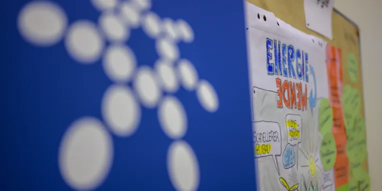 Logo der Region auf blauem Grund, dahinter eine Metaplanwand mit Karte und Flipchartzeichnung