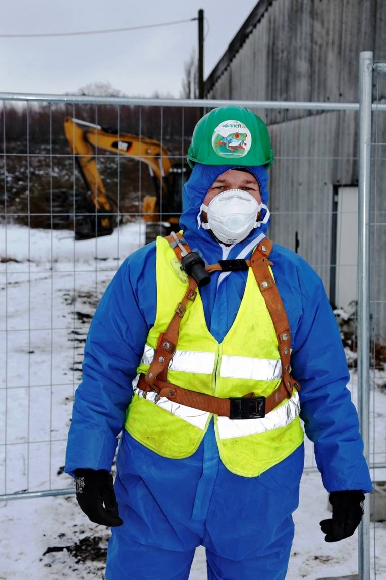 Person in Schutzkleidung mit Atemschutzmaske