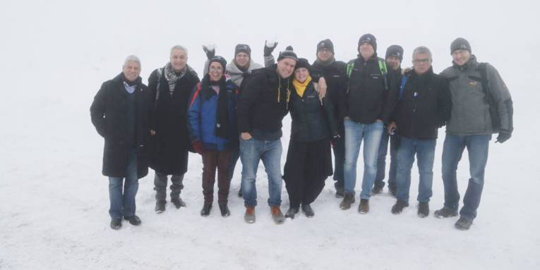 Elf Personen stehen im Schnee