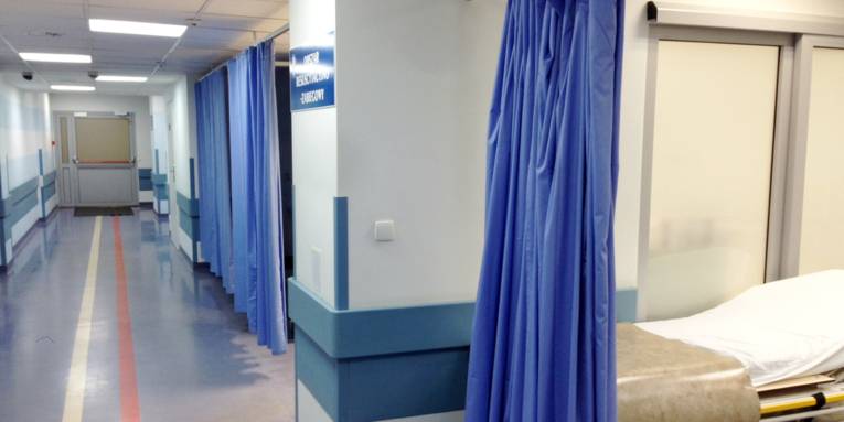 Krankenhausflur, Vorhänge trennen Nischen ab.