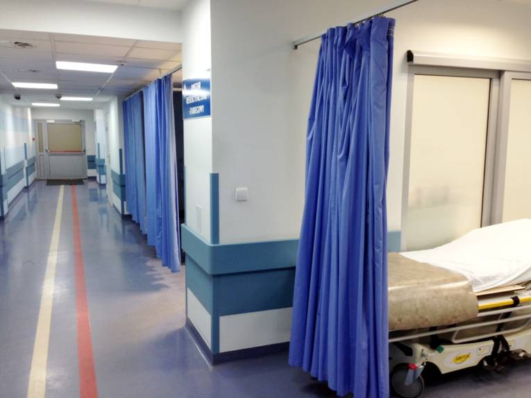 Krankenhausflur, Vorhänge trennen Nischen ab.