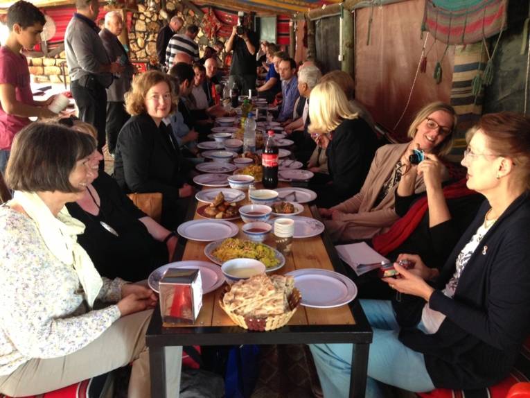 Eine Gruppe von Menschen in einem Beduinenzelt beim Essen