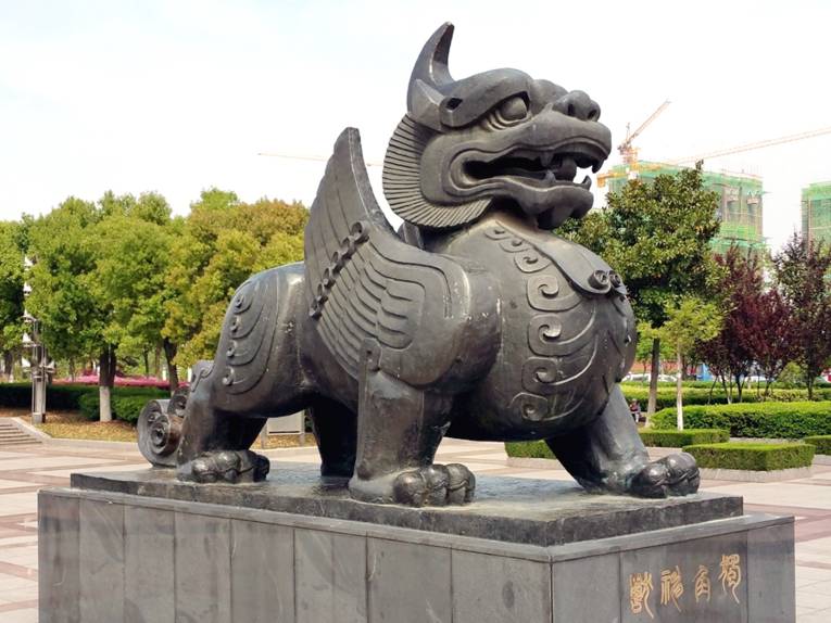 Denkmal eines Wesens mit vier Beinen, Flügeln und einem Horn.