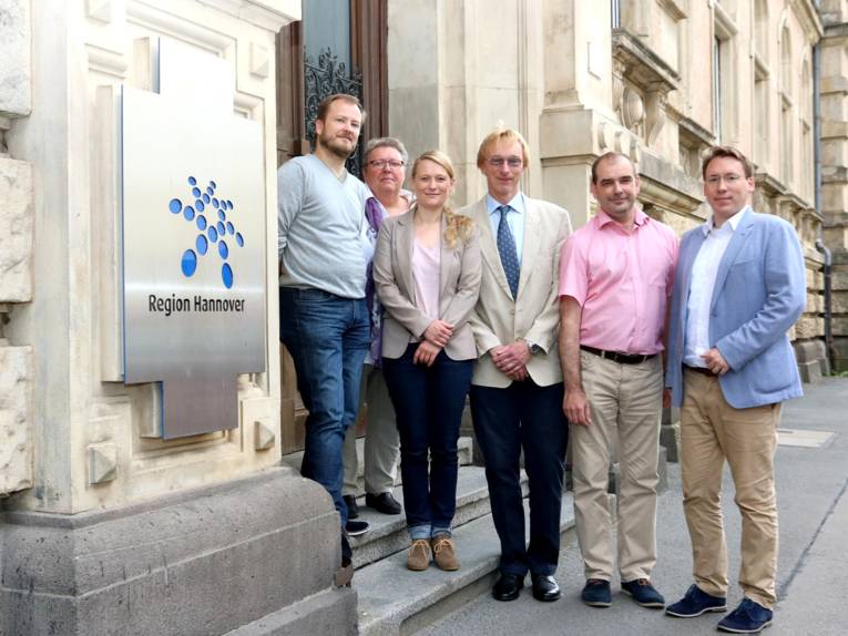 Eine Gruppe von Frauen und Männern auf der Treppe eines Gebäudes
