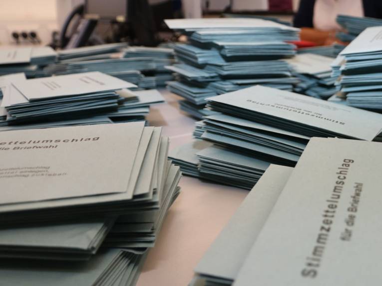 Blaue Briefwahlumschläge auf einem Tisch.